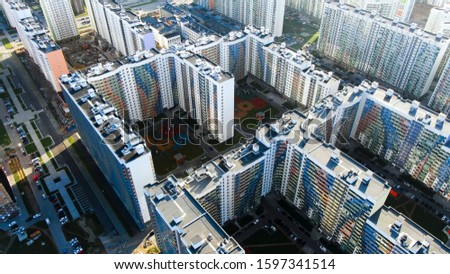 Top view of city street with newly built residential houses, real estate concept. Motion. Birds eye top view of white buildings with colorful balconies on a summer day.