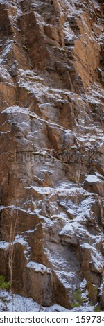 Cliffs of an abandoned granite quarry covered with snow. Industrial Landscape. Vertical Web Banner.