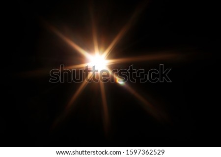 Easy to add lens flare effects for overlay designs or screen blending mode to make high-quality images. Abstract sun burst, digital flare, iridescent glare over black background. Royalty-Free Stock Photo #1597362529