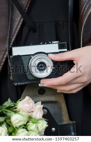 Оld vintage camera in the hands of a girl photographer.