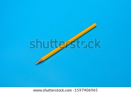yellow crayon pencil on blue background.