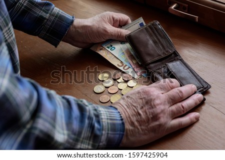 Old man's hands, count money, Euros. The concept of poverty, low income, austerity in old age. Royalty-Free Stock Photo #1597425904