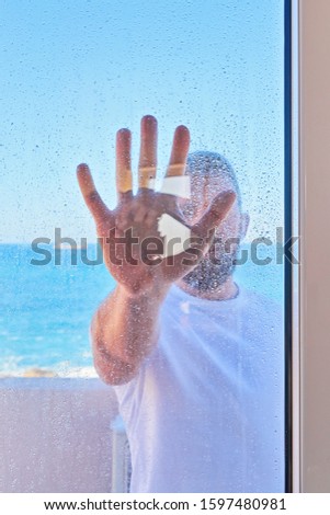 Caucasian man with raised hand through window glass. Problem of social domestic violence concept