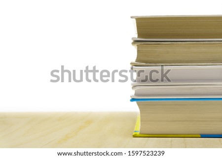 Stack of books on wooden desk on white background