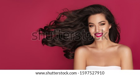 Hair care. Beautiful Brunette Woman Portrait with brown eyes and Healthy Long Shiny Wavy black hair. Volume shampoo. 
