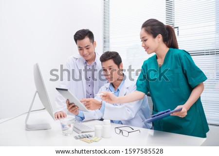 Group of doctors and nurses examining medical report of patient. Team of doctors working together on patients file at hospital.
