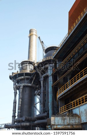 an abandoned steel mill with a blue sky outside