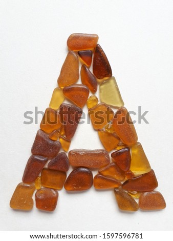 Letter A monogram made by brown sea glass, isolated initial