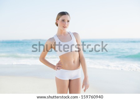 Attractive slender woman standing hand on hips on the beach