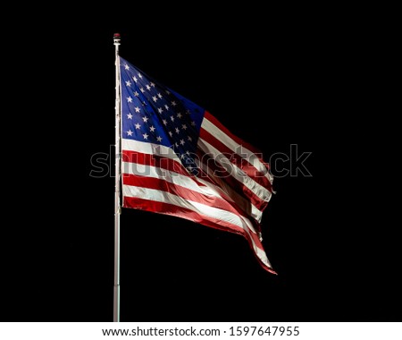 USA, Nevada, Mineral County: Stars and Stripes. A lit American flag flaps in the wind against a black night field outside the Hawthorne Army Depot, United States Army Base.