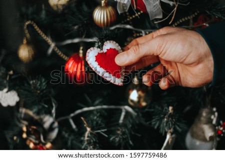 Saint Valentine s Day concept. Man holding red felt hearts in his hands with decorations in the background. New year concept. 
