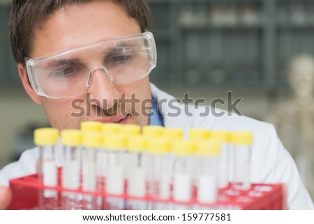 Extreme close-up of a male researcher  looking at test tubes in the lab