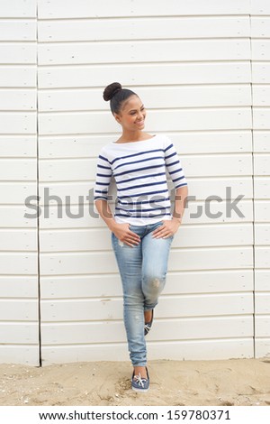 Full length portrait of a cheerful young woman relaxing outdoors