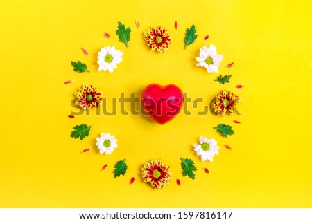 pattern of round frame of flowers white, asters, green leaves, red heart isolated on yellow background Flat lay Top view Sesonal concept Hello autumn, spring or summer, Good morning Holiday card