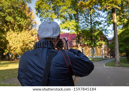 Man takes picture with digital camera outside.