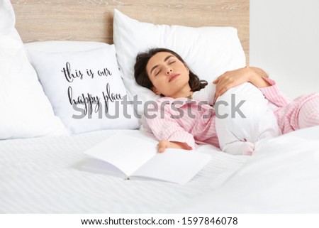 Young woman and her baby sleeping in bed