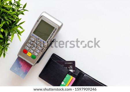Pay by credit card in shop. Terminal and card on white background top-down copy space