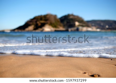Close-up of sand with unfocused background on La Concha beach in San Sebastian
