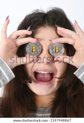 Pretty Girl keeps the eye instead two silver cryptocurrency bitcoin in hands on white background