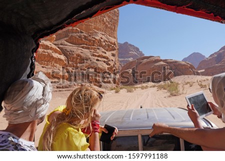 Jordan ,  The Wadi Rum Desert - tourist visiting the desert with 4x4 jeep car     taking pictures                         