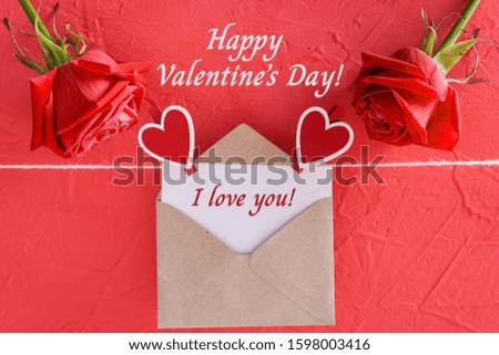 Inscription i love you on card with craft envelope, Happy Valentine Day on red background, roses and hearts on clothespins