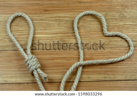 loop and heart of rope on wooden background