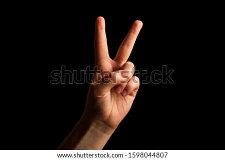 Hand Showing Sign of V Alphabet in American Sign Language (ASL), isolated on black background. Sign language