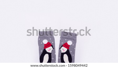 
gray warm christmas socks with penguins on a light background