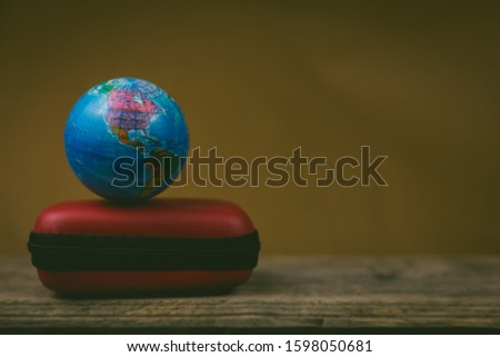 vintage globe on red baggage, a missions concept.