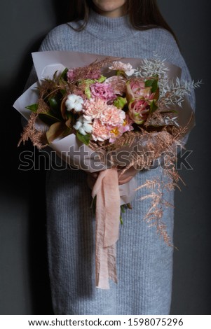 Girl holds in her hands original bouquet in vintage style, greeting background or concept