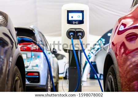 A modern electrical fast charger for the electrical or hybrid PHEV automobiles. An Energy power of future. Ecology friendly charger concept. Home electric car battery charger. Royalty-Free Stock Photo #1598078002
