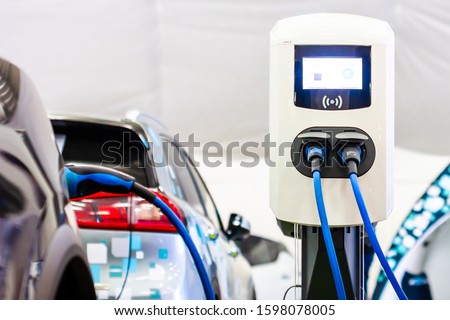A modern electrical fast charger for the electrical or hybrid PHEV automobiles. An Energy power of future. Ecology friendly charger concept. Home electric car battery charger. Royalty-Free Stock Photo #1598078005