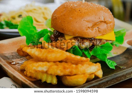 
Pork hamburger with french fries on a rectangular wooden plate