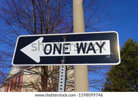 One way street sign with blue sky background.