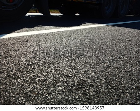 Asphalt road with a truck passing by
