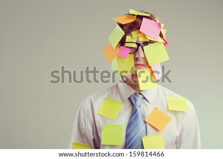 Office worker with post-its all over his face Royalty-Free Stock Photo #159814466