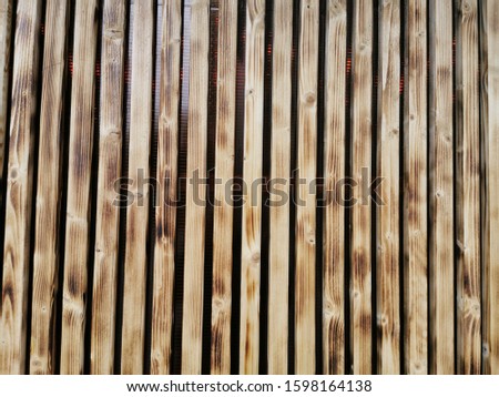 Wooden thin slats with traces of firing. Thin vertical slats.Wooden background. Abstract background.