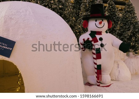 
Standing snow man before Christmas trees