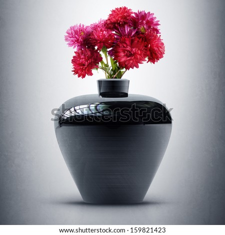 Black vintage vase with a bunch of red flowers. High resolution