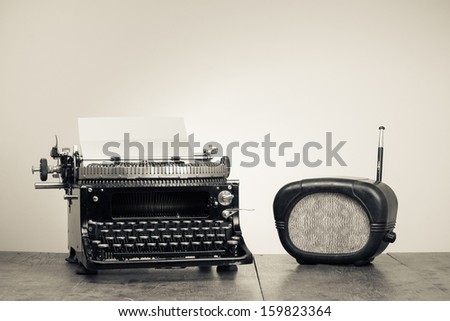 Vintage typewriter, old radio on wood table sepia photo