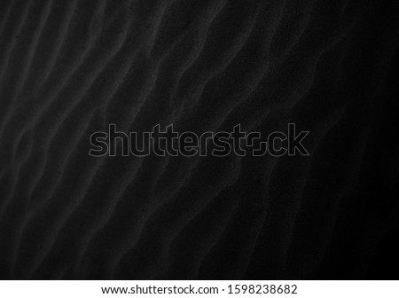 Black Sand beach macro photography. Texture of black volcanic sand for background. Close-up macro view of volcanic sand surface black color. Black and white poster texture sand in the desert.  Royalty-Free Stock Photo #1598238682