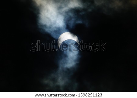 solar eclipse surrounded by clouds