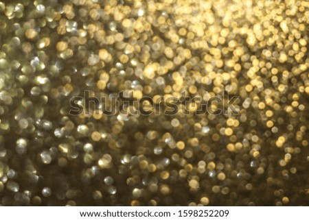 Golden holiday abstract glitter defocused background with blinking stars. Abstract christmas lights on background. Blurred bokeh.