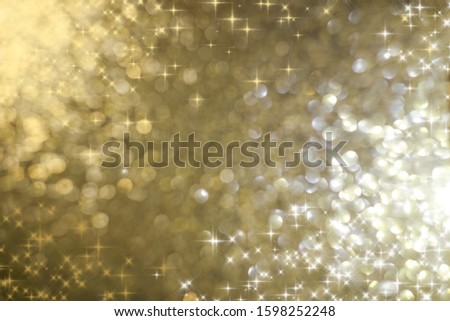 Golden holiday abstract glitter defocused background with blinking stars. Abstract christmas lights on background. Blurred bokeh.