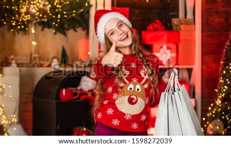 perfect day ever. small shopaholic. child smile with paper bags. holiday gift shopping. christmas is here. new year winter vacation. kid reindeer sweater and santa hat. shopping packages for family.