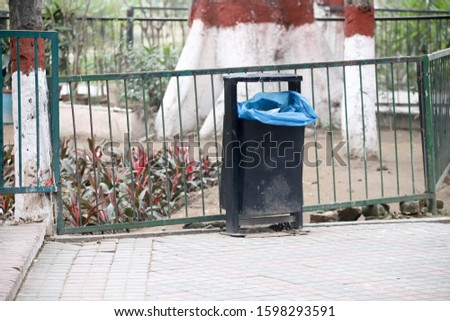 A Black Trash Basket Isolated In the Park