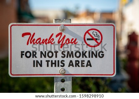 Sign reading “Thank You for Not Smoking in this Area” with a mix of cursive writig and capital letters along with a no smoking graphic symbol