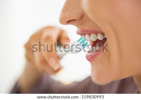 Closeup on happy young woman brushing teeth Royalty-Free Stock Photo #159830993