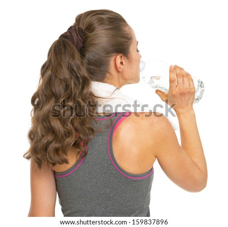 Fitness young woman drinking water . rear view