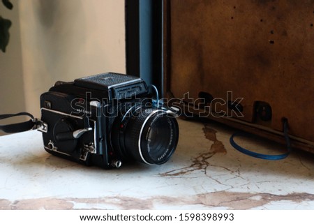 Retro Black camera on white table background.